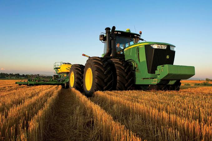 Green tractor working in a field